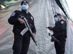 Policías resguardan el tractocamión frigorífico con cuerpos exhumados en las fosas clandestinas halladas en San Fernando. EFE  /