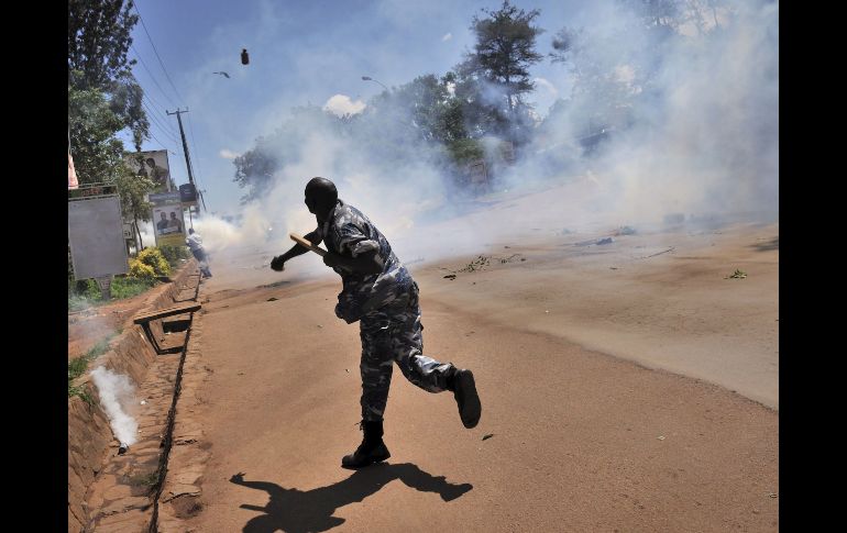 Un policía lanza una bomba de gas lacrimógeno durante la  protesta. ARCHIVO  /