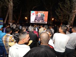 Argelinos escuchan el mensaje del jefe de Estado, en las calles del país. AFP  /