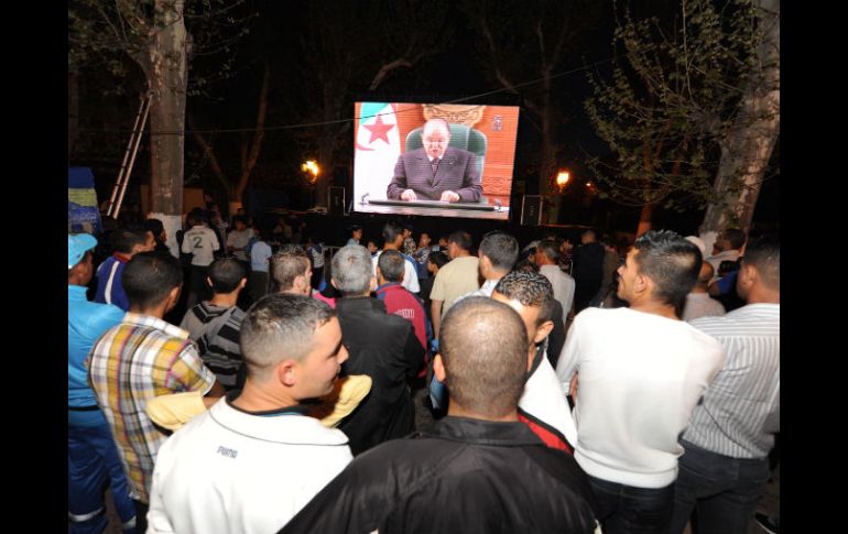 Argelinos escuchan el mensaje del jefe de Estado, en las calles del país. AFP  /
