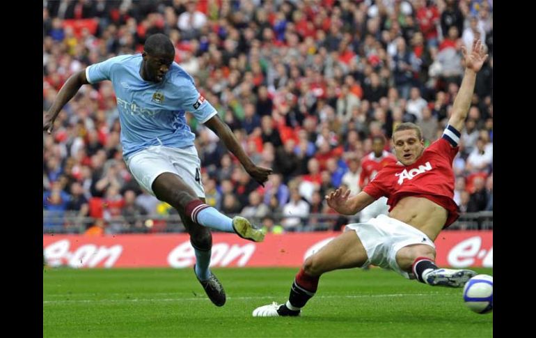 Toure Yaya (izq.) dispara sobre la marca de Vidic para anotar el gol de la victoria del City. REUTERS  /