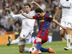 El delantero argentino, Lionel Messi, lucha por el balón ante el defensa del Real Madrid, Sergio Ramos, durante el Clásico Español. EFE  /