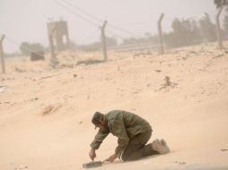 Un rebelde libio prepara una mina de tierra cerca de la principal carretera de Ajdabiya, Libia. EFE  /