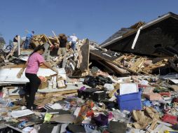 Una mujer busca lo que queda de sus pertenencias luego del paso de  los tornados, en Carolina del Norte. AFP  /