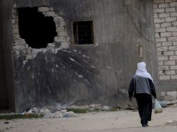 Un hombre libio camina cerca de un edificio dañado por un misil en Ajdabiya. EFE  /