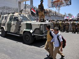Dos niños yemeníes pasan frente a un vehículo militar. EFE  /