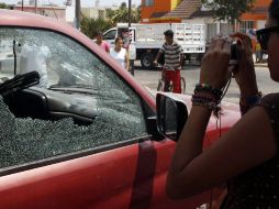 Una mujer fotografía una de las camionetas en las que viajaban los sicarios. EFE  /