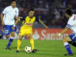 El jugador del América, Vicente Sánchez (c) disputa el balón con Sebastián Coates del Nacional de Uruguay. EFE  /