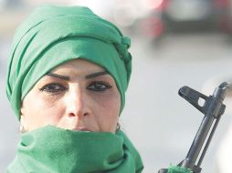 Una mujer, miembro de las fuerzas gadhafistas vigila las calles de Trípoli. AFP  /