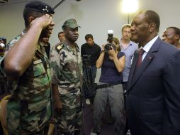 El general Philippe Mangou, jefe de las Fuerzas de Seguridad de Laurent Gbagbo, saluda al presidente Alassane Outtara. ARCHIVO  /