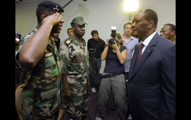 El general Philippe Mangou, jefe de las Fuerzas de Seguridad de Laurent Gbagbo, saluda al presidente Alassane Outtara. ARCHIVO  /