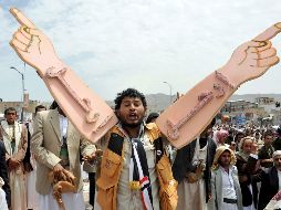 Un opositor yemení sujeta dos brazos en los que se puede leer ''márchate''. EFE  /
