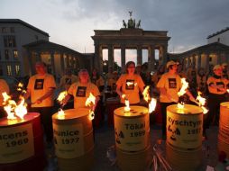 Activistas de Greenpeace realizan un número de percusión frente a la Puerta de Brandemburgo, en Berlín. EFE  /