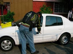 Personal del Instituto Jalisciense de Ciencias Forenses analizó un auto compacto para obtener huellas de los homicidas. M. PATIÑO  /