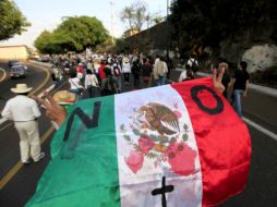 Dio inicio la Marcha Nacional por la Paz y la Justicia. Un participante carga una Bandera mexicana manchada de 'sangre'. AP  /