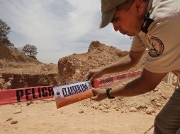 Un elemento de Protección Civil y Bomberos de Jalisco coloca los sellos de clausura en la mina de ópalo Pata de Gallo. S. NÚÑEZ  /