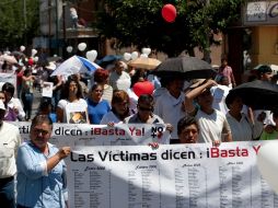 Personas marchan por la paz en Ciudad Juárez. En sus pancartas figuran nombres de víctimas de la violencia en el lugar. AFP  /