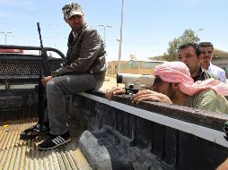 Un combatiente rebelde libio (a la derecha) usa binoculares para observar la frontera en el cruz de Wazin. EFE  /