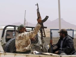 Un rebelde libio alza su rifle en la parte trasera de una camioneta en la parte libia del paso fronterizo de Wazin. EFE  /