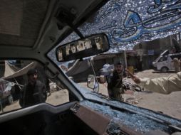 Policías inspeccionan los restos de una camioneta dañada tras uno de los atentados. AP  /