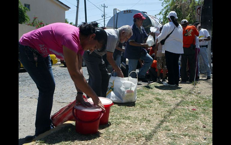 La gente acudió con recipientes de todos tamaños para recibir leche gratis. A. HINOJOSA  /
