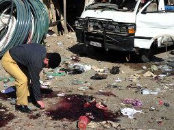 Un policía paquistaní recoge pruebas en el sitio de un ataque suicida. AFP  /