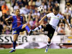 El jugador de Valencia, Joaquín Sánchez, compite ante Valdo Lopés del Levante. AFP  /