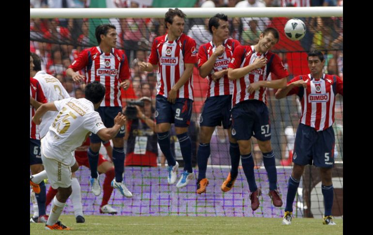 Javier Cortés anota de tiro libre el primer gol de Pumas, superando la barrera rojiblanca para vencer al arquero Luis Michel. AP  /
