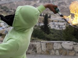 Un palestino lanza un cóctel Molotov hacia la policía israelí durante los enfrentamientos registrados en Jerusalén. EFE  /