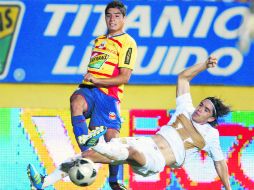 Enrique Pérez, de Morelia, y Efraín Velarde, de Pumas, disputan un balón, anoche en el Morelos. AP  /
