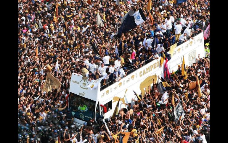 Miles de seguidores festejan con los jugadores de Pumas, a su paso por la avenida Reforma. EFE  /