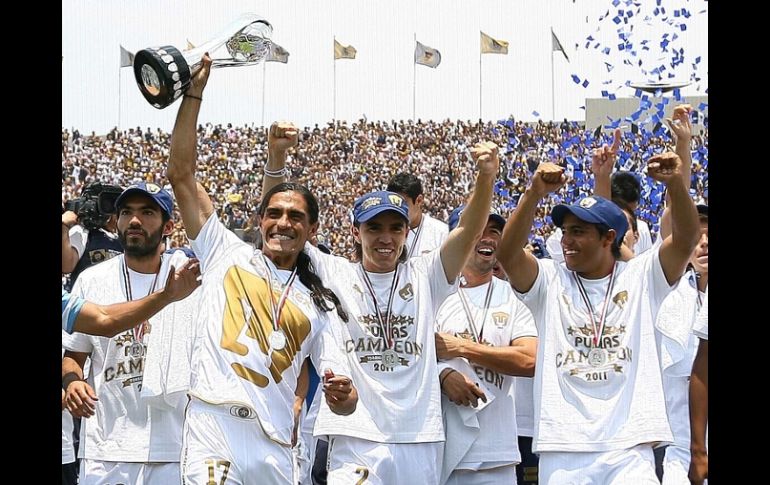 Francisco Palencia sostiene el trofeo del torneo y celebra el campeonato junto a sus compañeros. MEXSPORT  /