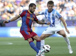 El jugador de Barcelona, Dani Alves, disputa un balón ante mediocentro del Málaga CF Ignacio Camacho. EFE  /