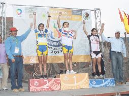 Liz Flores (centro) en el podio de primer lugar y con collarín luego de una fuerte caída. ESPECIAL  /