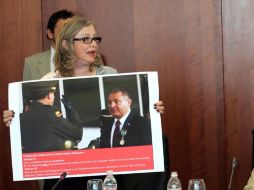 La diputada Laura Itzel Castillo, muestra una imagen de García Luna recibiendo la medalla en Colombia. ARCHIVO  /