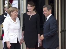 Nicolás Sarkozy (d) y su esposa Carla Bruni-Sarkozy (c) dan la bienvenida a la canciller alemana Angela Merkel. EFE  /