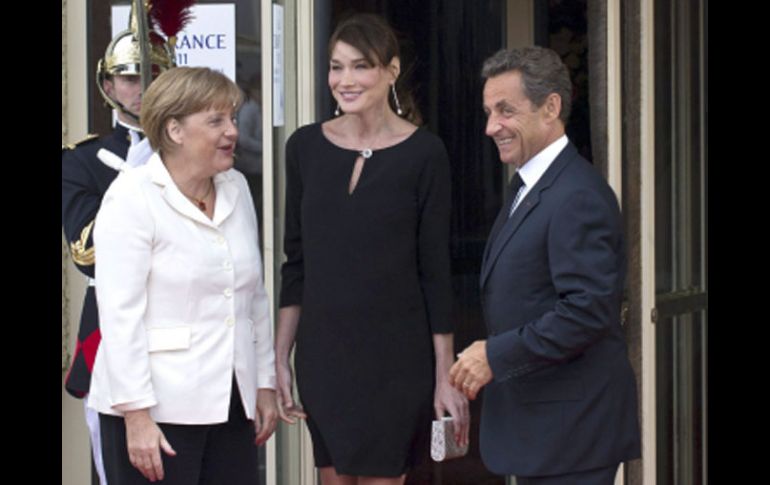 Nicolás Sarkozy (d) y su esposa Carla Bruni-Sarkozy (c) dan la bienvenida a la canciller alemana Angela Merkel. EFE  /