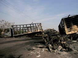 Camiones quemados quedaron en una carretera de Buenavista Tomatlán luego de los enfrentamientos entre grupos armados. AFP  /