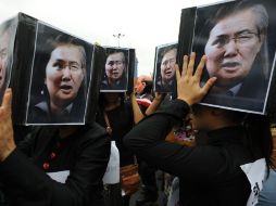 Manfestantes en contra de Keiko Fujimori protestan en la calle con carteles que llevan la cara del padre y la hija Fujimori. EFE  /