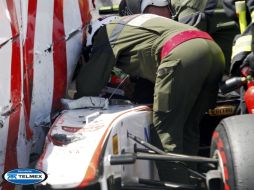Un comisario ayuda a Sergio Pérez, tras sufrir un accidente durante la última parte de la sesión de clasificación. EFE  /