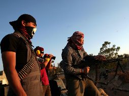 Un combatiente rebelde dispara una ametralladora en la línea de frente durante los combates con tropas leales a Gadhafi. EFE  /