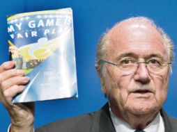 Joseph Blatter, directivo de la FIFA, muestra a la prensa el código de ética del organismo  /