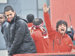 El atacante mexicano Javier Hernández y el defensor Rafael da Silva saludan a los aficionados durante el desfile. AFP  /
