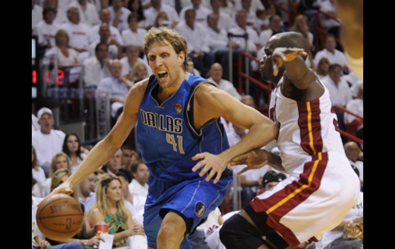 El alemán Dirk Nowitzki (con el balón), de los Mavericks de Dallas, intenta meterse a la pintura de Miami. EFE  /