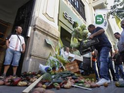 Ciudadanos molestos tiran todas su verduras contaminadas por e.coli en las calles de Valencia, España. AP  /