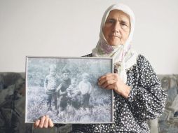 Munira Salihovic muestra una foto de sus tres hijos y su esposo, quienes murieron en la matanza de Srebrenica. REUTERS  /