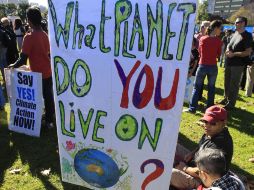 Usan carteles para promover el impuesto sobre el carbono en Sídney. AP  /