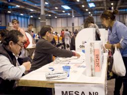 Una peruana se dispone a votar en una de las mesas instaladas en el Pabellón 4 de IFEMA, en España. EFE  /