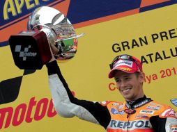 El australiano Casey Stoner sube a lo más alto del podio con el trofeo en mano. AFP  /