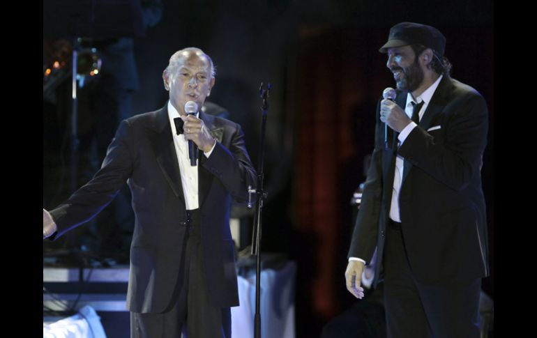 El diseñador dominicano (i) comparte el escenario con su compatriota Juan Luis Guerra (d). AP  /